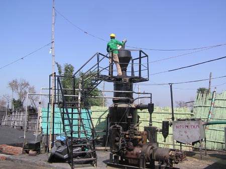 Filling a gasifier plant with rice husk, Tamkuha, Bihar